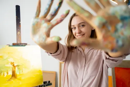 Happy woman engaged in painting during an art therapy session