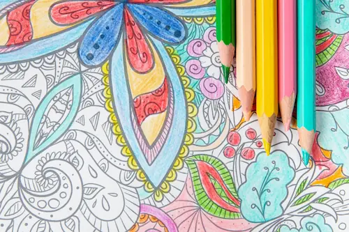 Person selecting colors while working on a mandala art coloring page